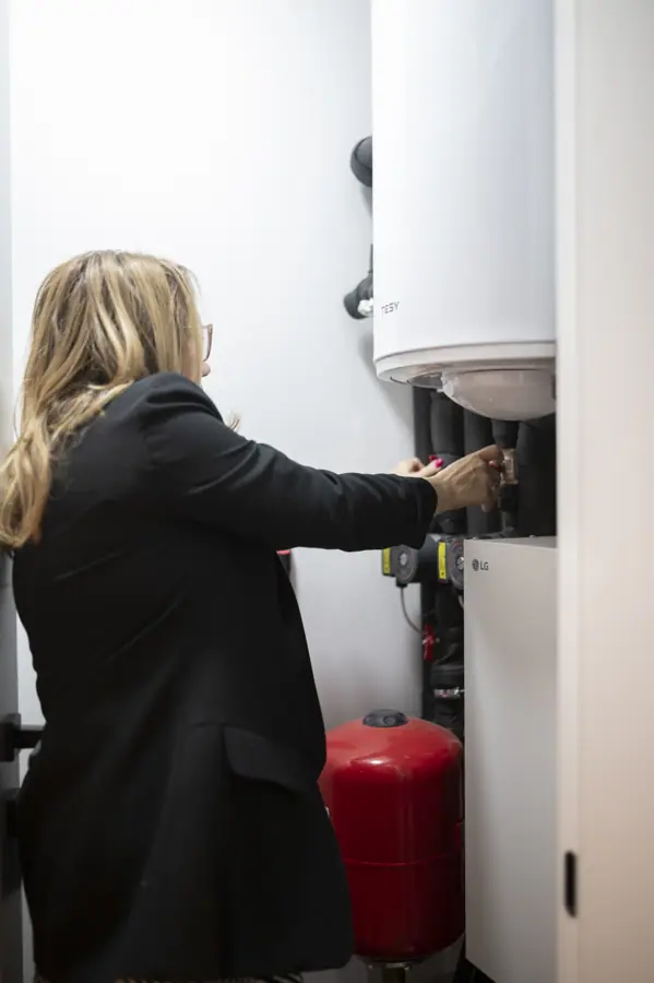 Beautiful businesswoman works on heating system in a utility room