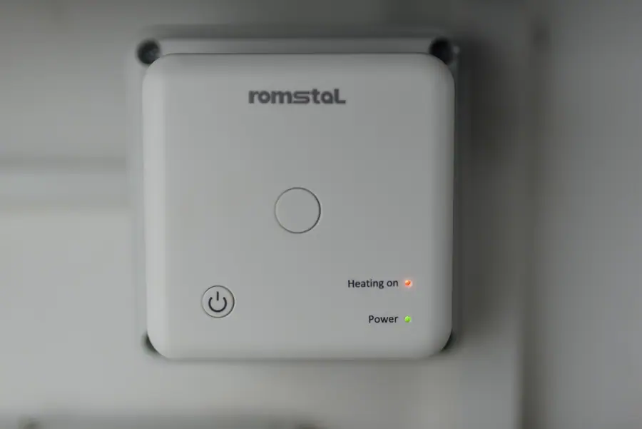 Smart heating control unit displayed on a wall with power indicator lights showing status in a home setting