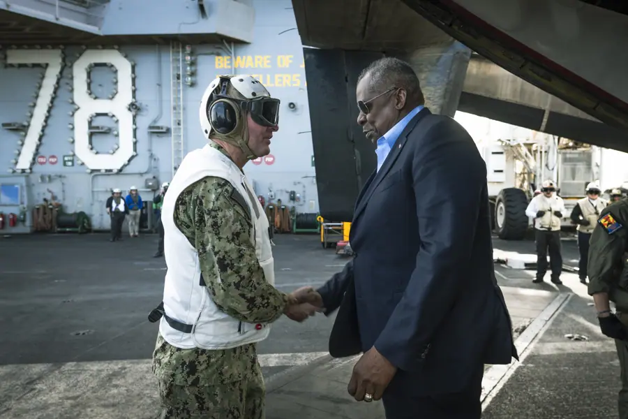 United States Secretary of Defense Lloyd Austin greets Admiral Stuart Munsch, Commander, U.S. Naval Forces Europe-Africa onboard USS Gerald R. Ford (CVN 78) underway in the Eastern Mediterranean, December 20, 2023