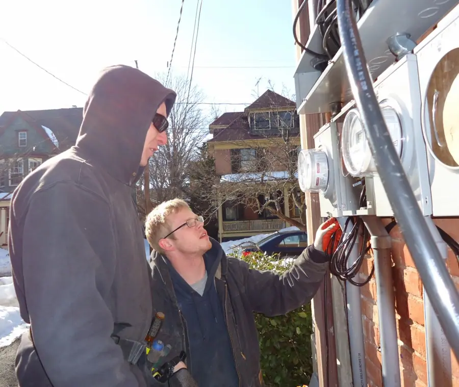 Electricians inspecting panels for separate house meters on multifamily in NJ