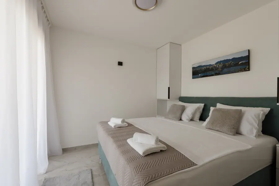 Cozy bedroom with two beds window and wall art in a simple setting