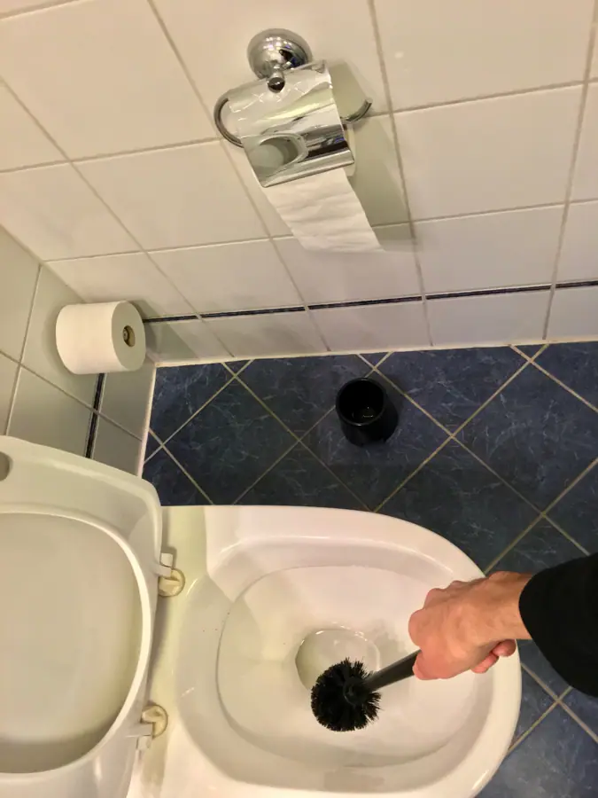 Bathroom in hotel in Bergen, Norway. 2016-03-16. Toilet brush cleaning toilet bowl,etc. Also wall and floor tiles