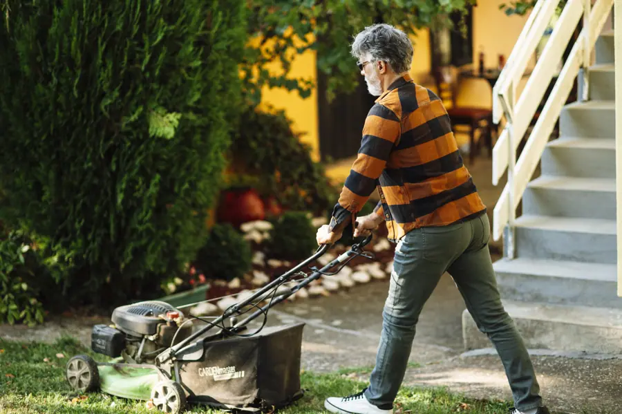 Man mowing the lawn in a suburban garden