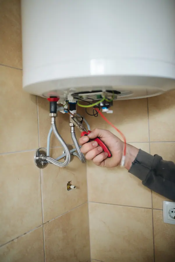 Plumber with pliers fix wires of water heater closeup
